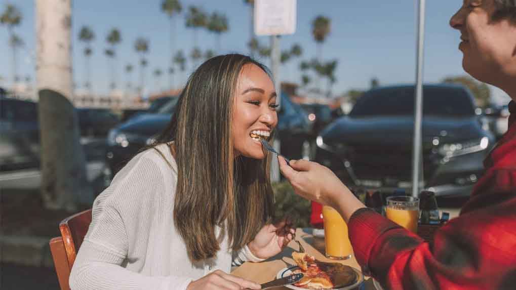 A couple eating outdoors.